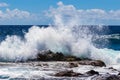 Wave breaking on rock in Hawaii; Deep blue ocean, blue sky and clouds in background. Royalty Free Stock Photo