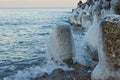 The wave breaks against an icy stone