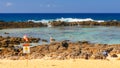 Wave breaks onto the rocks and pours into the tide pool at shark cove Royalty Free Stock Photo