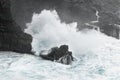 A wave breaks in stormy weather on a rocky coast Royalty Free Stock Photo