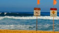 Dangerous surf conditions and a no swimming sign on the beach