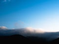 Wave of fog above dark mountains.