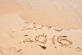 The wave is covering the digits 2015. New Year concept. Inscription 2015 and 2016 on a beach sand. Happy New Year 2016. Royalty Free Stock Photo