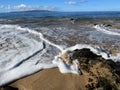 A wave crashes into the rocky shoreline of Hawaii