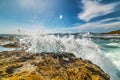 Wave crashihng on a yellow rock