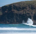 A wave crashing against a cliff at the Sandfly Bay Beach in Otago Penninsula near Dunedin in New Zealand