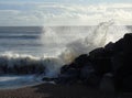 Wave crashing against rocks on a sunny day Royalty Free Stock Photo