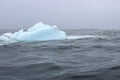 Wave crashing against small iceberg bit floating in sea Royalty Free Stock Photo