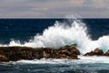 Wave crashing on dark lava rock;white spray in the air, Dark ocean and clouds in background. Black Sand Beach, punaluu, Hawaii. Royalty Free Stock Photo