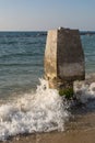 Wave crashing on a stone column