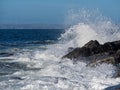 Wave crushes on rocks creating splash. Royalty Free Stock Photo