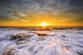 The wave flows over weathered rocks and boulders at North Narrabeen