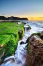 The wave flows over weathered rocks and boulders at Turimetta Be