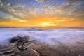 The wave flows over weathered rocks