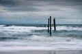 Wave hitting decay wooden bridge on the beach in stormy