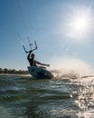 Wave kitesurfer doing a turn in the water while being backlit by a beautiful sun star