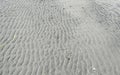 Wave pattern beach sand with footprints