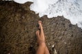 A wave reaches the feet of a girl on the beach and wets them. Beach, summer and vacation concepts