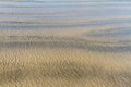 Wave ripples over golden sandy beach abstract