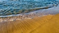 Wave of the sea sand and pebbles close up at sunset Royalty Free Stock Photo