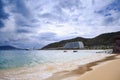 Wave Surf on Golden Beach Distant Hotel Sky Clouds Royalty Free Stock Photo