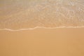 Wave of water on clear golden sandy beach