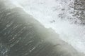 Wave of water flows down from a breakwater during a storm at sea