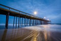 Waves in the Atlantic Ocean and the fishing pier at twilight, in Royalty Free Stock Photo
