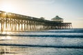 Waves in the Atlantic Ocean and the pier at sunrise, in Folly Beach, South Carolina Royalty Free Stock Photo