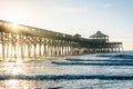 Waves in the Atlantic Ocean and the pier at sunrise, in Folly Beach, South Carolina Royalty Free Stock Photo