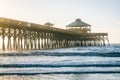 Waves in the Atlantic Ocean and the pier at sunrise, in Folly Beach, South Carolina Royalty Free Stock Photo