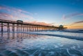 Waves in the Atlantic Ocean and the pier at sunrise, in Folly Beach, South Carolina Royalty Free Stock Photo