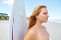 The waves await...a young woman standing on the beach with her surfboard looking out at the ocean. Royalty Free Stock Photo