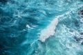 Waves and azure water as a background. View from high rock at the ocean surface. Natural summer seascape.