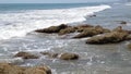 Waves break against rocks on the shore. Water splashes. Summer dark day.