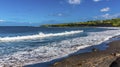 Waves break on a dark volcanic sand beach in St Kitts Royalty Free Stock Photo