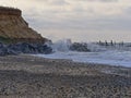 Waves break on rocks protecting soft cliffs from erosion Royalty Free Stock Photo