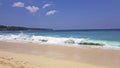 The waves break on the sandy beach, the foam covers the sand.