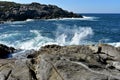 Seascape background: Waves splashing against the rocks. Blue sea and white foam. Sunny day, blue sky, Galicia, Spain. Royalty Free Stock Photo