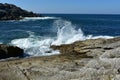 Waves breaking against the rocks. Wild sea, cliff and blue water. White foam, blue sky, sunny day. Galicia, Spain. Royalty Free Stock Photo