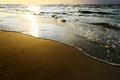 Waves breaking on the beach at sunset. Royalty Free Stock Photo