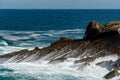 Waves breaking and forming sea foams on rocks Royalty Free Stock Photo