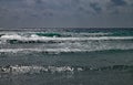 Waves breaking onshore beneath a stormy sky