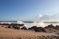 Waves breaking on rocky beach with clouds on the horizon