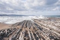 Waves breaking on a sandy beach on a stormy day. Royalty Free Stock Photo