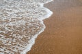 Waves breaking on shore of the sea. closeup of sea foam on wet sand