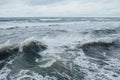 Waves Breaking and Spraying at High Seas and Strong Winds. Storm at the sea in autumn cloudy rainy day