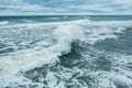 Waves Breaking and Spraying at High Seas and Strong Winds. Storm at the sea in autumn cloudy rainy day