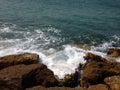 The waves breaking on a stony beach, forming a spray, splits waves against rocks in the sea. Royalty Free Stock Photo