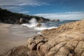 Waves crash onto a small sandy cove near Calvi in Corsica